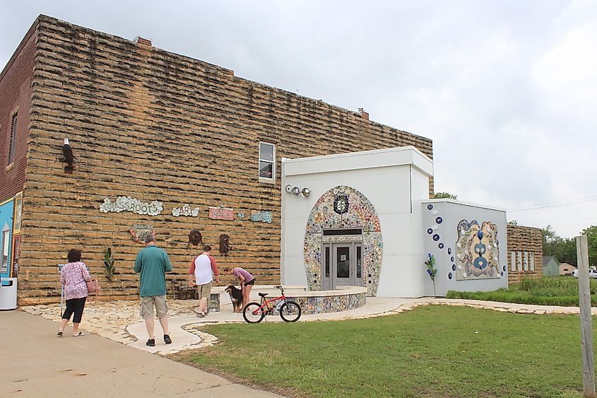 A shot of the Lucas Kansas City Bathroom that was vote Second Best Rest Room in the United States thats beside a lime stone Building with green grass