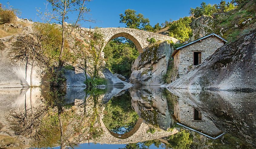 Arched stoned bridge in Mariovo over river. 