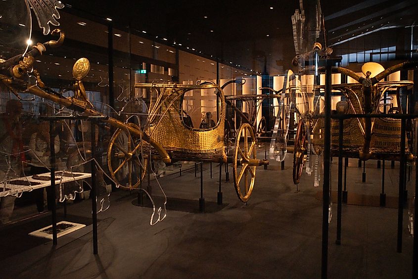 Ancient golden chariots of King Tutankhamun displayed in glass cases
