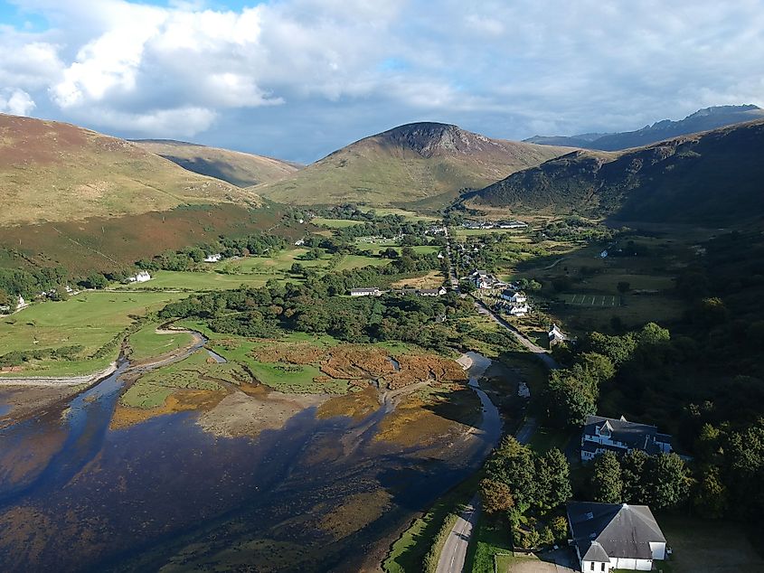 An aerial of the water, buildings and mountains in the Isle of Arran, Scotland.
