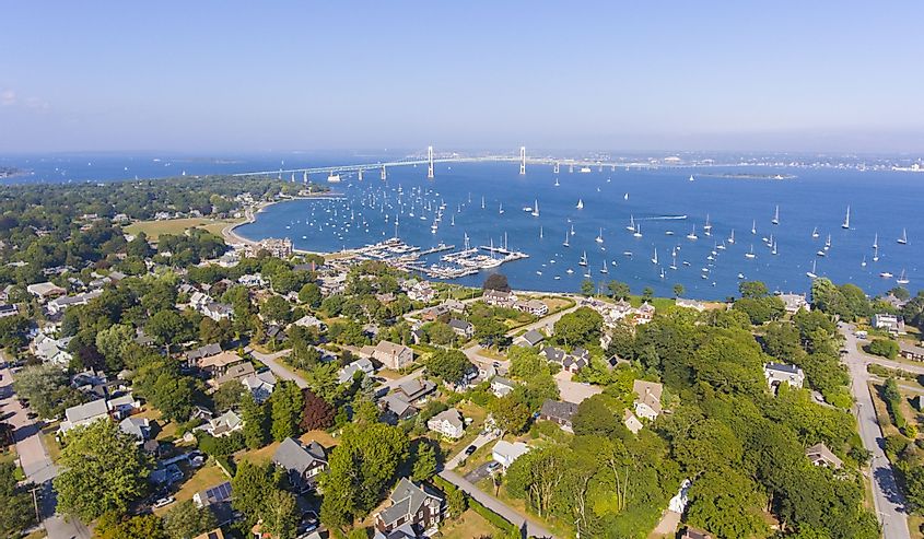 Aerial view of Narragansett Bay and town of Jamestown with homes and green trees in summer with a bridge in the background
