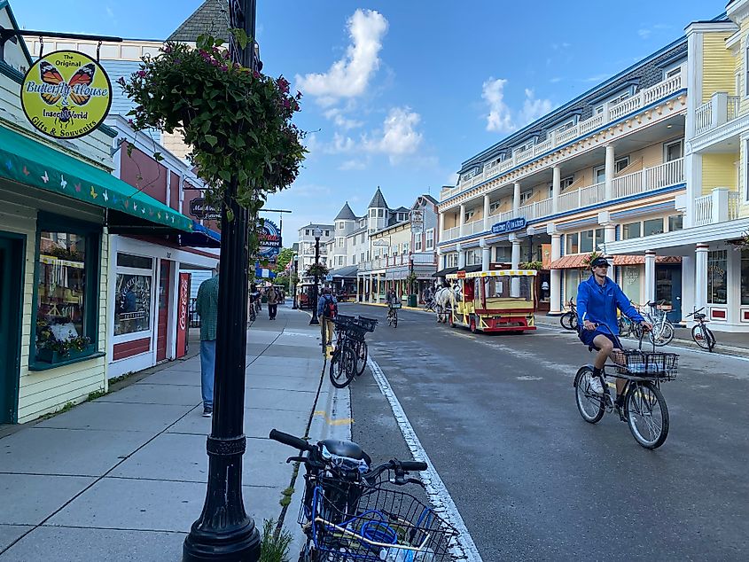 A cyclist and a horse-drawn carriage pass in opposite directions along this car-free Victorian street.