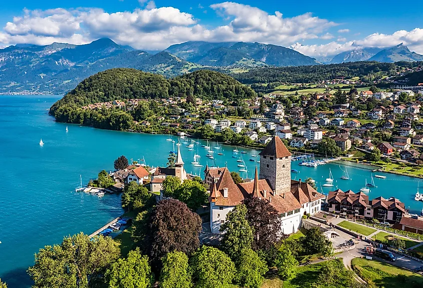 Spiez Castle and its adjacent church on the shore of Lake Thun at sunset.
