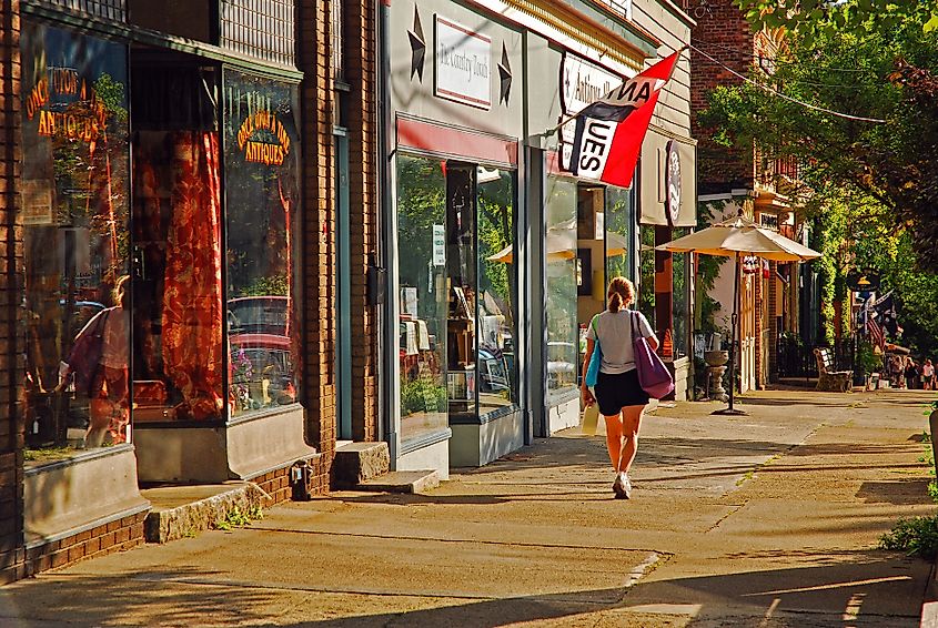 Cold Spring, New York: A young woman walks past independent stores and boutiques on a sunny day.