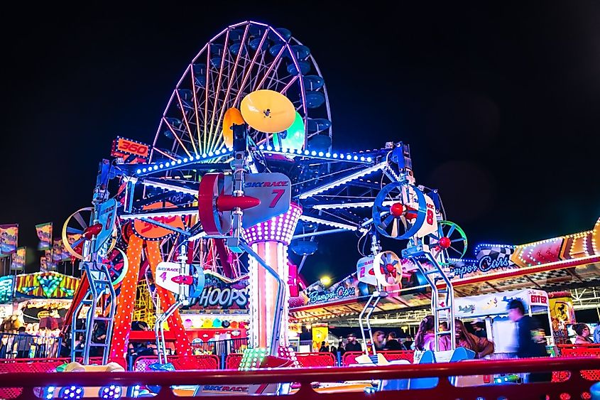 View of Jolly Roger Amusement park seen from the Ocean City Maryland Boardwalk on a summer night with fun colorful rides seen.