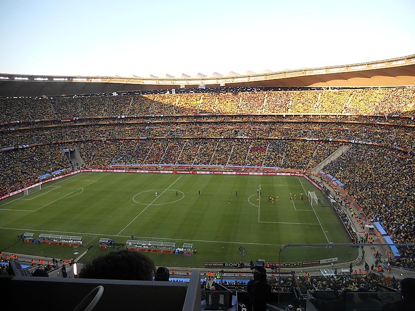 FNB Stadium. In Wikipedia. https://en.wikipedia.org/wiki/FNB_Stadium By 2010 World Cup - Shine 2010 - originally posted to Flickr as First game of the 2010 FIFA World Cup, South Africa vs Mexico, CC BY 2.0, https://commons.wikimedia.org/w/index.php?curid=10610077