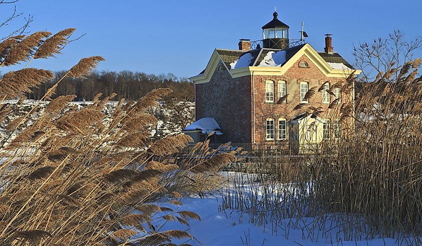 Windswept sea oats front the snow clad Saugerties Lighthouse on the frozen Hudson River in Upstate New York