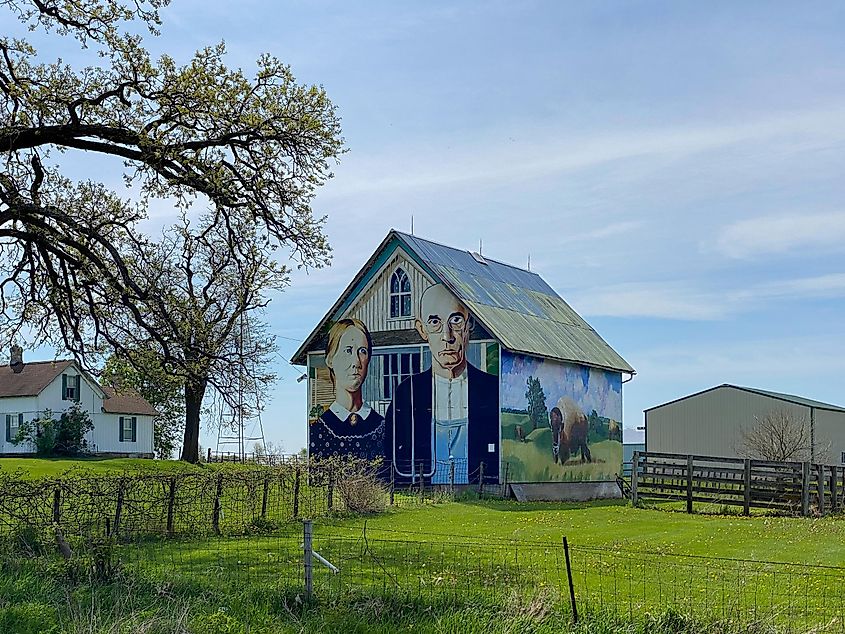 Mount Vernon, Iowa - May 1, 2023: American Gothic Barn, barn-sized rendition of Grant Wood's most famous, and most parodied, painting of farming couple and nearby Iowa gothic farm house.