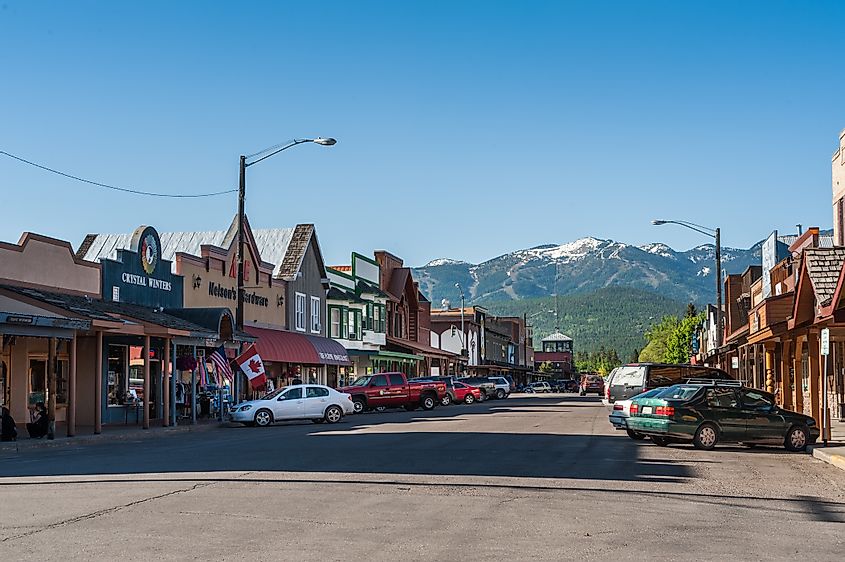 Cars angle-parked along the Main Street in Whitefish, Montana with stunning mountains in the backdrop.