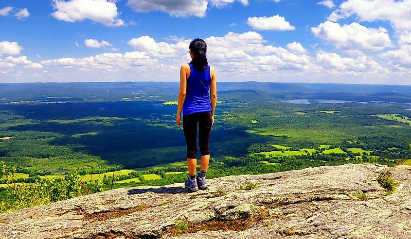 A woman standing on Mount Race top on the Appalachian trail in Massachusetts connecticut united states.