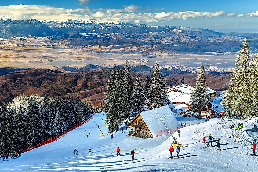 O frumoasă stațiune de schi montană cu cabane din lemn și o telegondolă. 