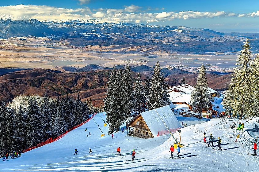 O frumoasă stațiune de schi montană cu cabane din lemn și o telegondolă. 