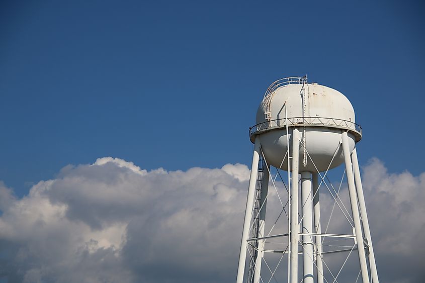 A tall water tower against a blue sky with clouds. Credit: Mitch Cox Photo/Shutterstock.com