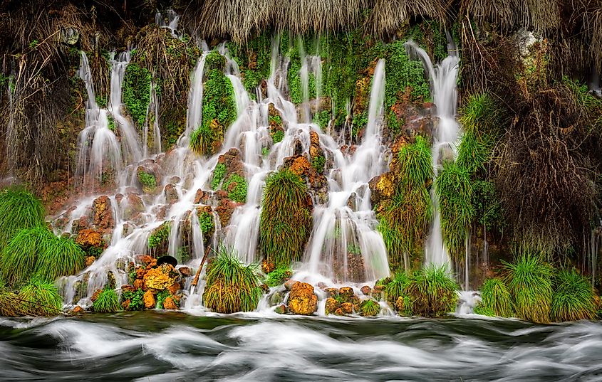 Thousand Springs state park waterfall flows into a river.