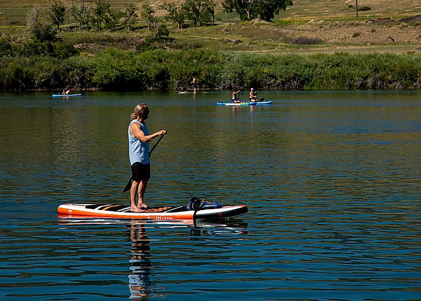 paddle boarder paddling on pond at Chatfield State Park, via Wayne Broussard / Shutterstock.com