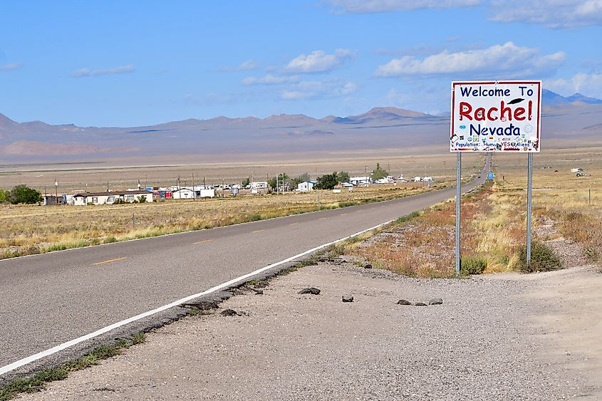 Roadsign "Welcome to Rachel Nevada" with the town of Rachel in the background.