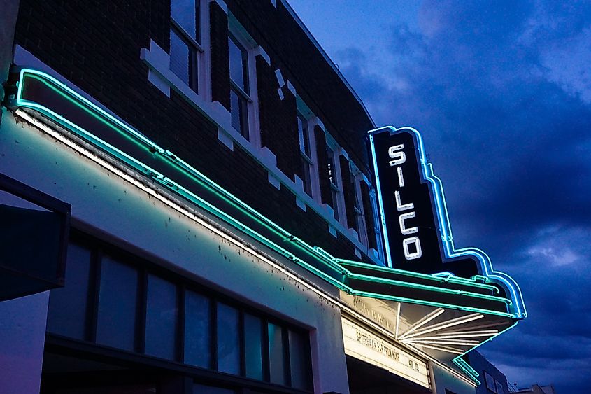 Historic Silco Theater in downtown Silver City, New Mexico, with its marquee lighted against a dramatic evening sky.
