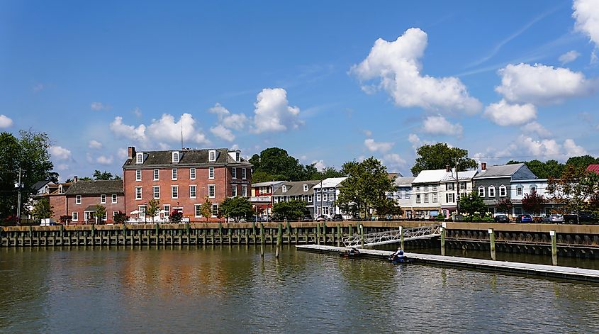 The panoramic view of the Central Hotel, townhouses, local stores and the pier by the bay on a summer day in Delaware City.