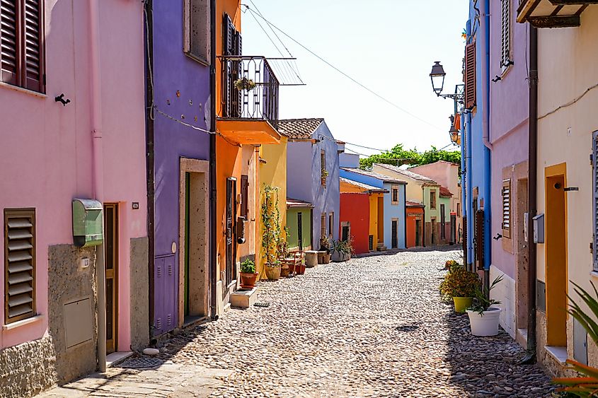 Narrow cobblestone street lined with colorful houses in the historic town of Bosa, Sardinia, Italy (Editorial credit: Alexandre.ROSA / Shutterstock.com)