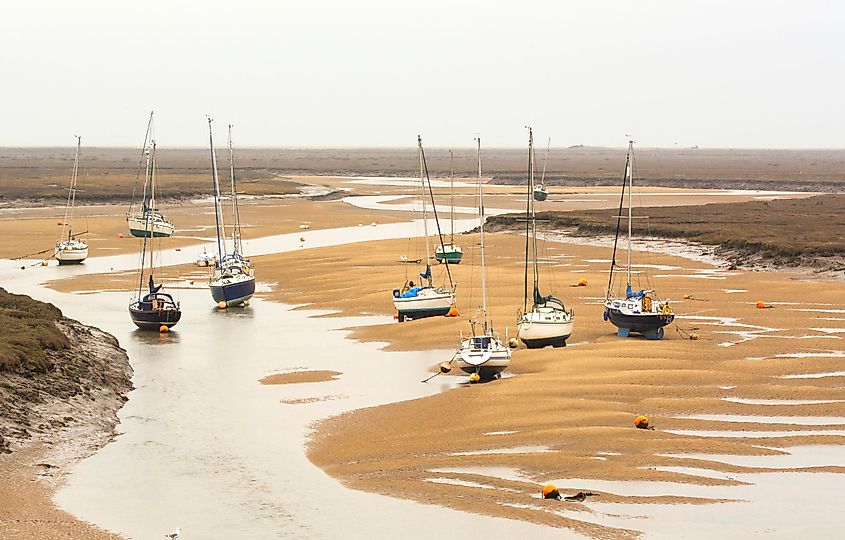 Small boats at low tide at Wells next the Sea, Norfolk, UK