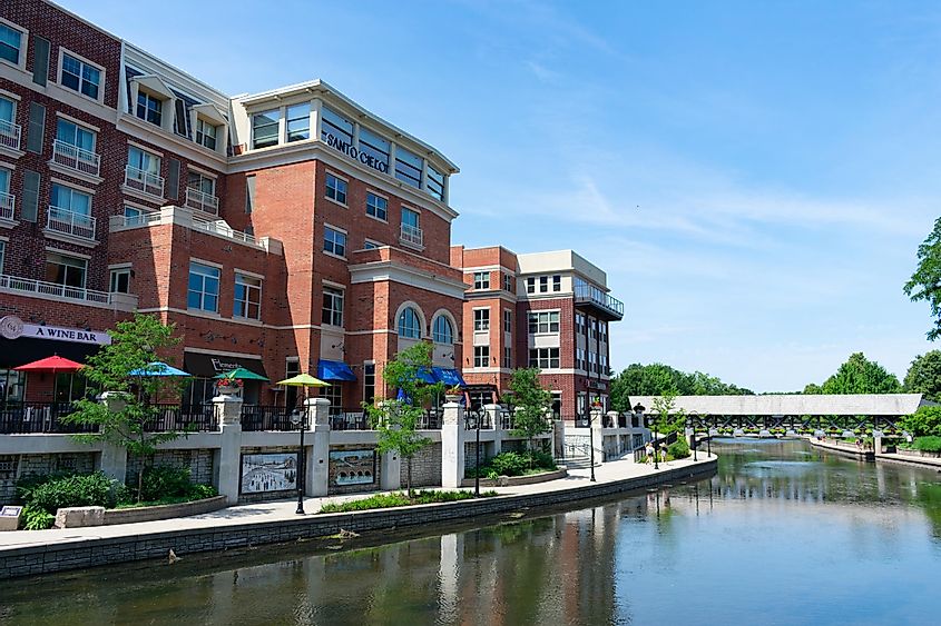 Buildings with Shops and Restaurants along the Naperville Riverwalk with a Covered Bridge in the Distance