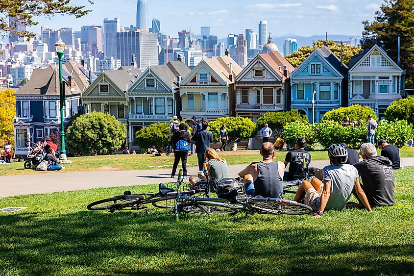 People enjoying outdoor activities and view of Painted Ladies houses in Alamo Square 