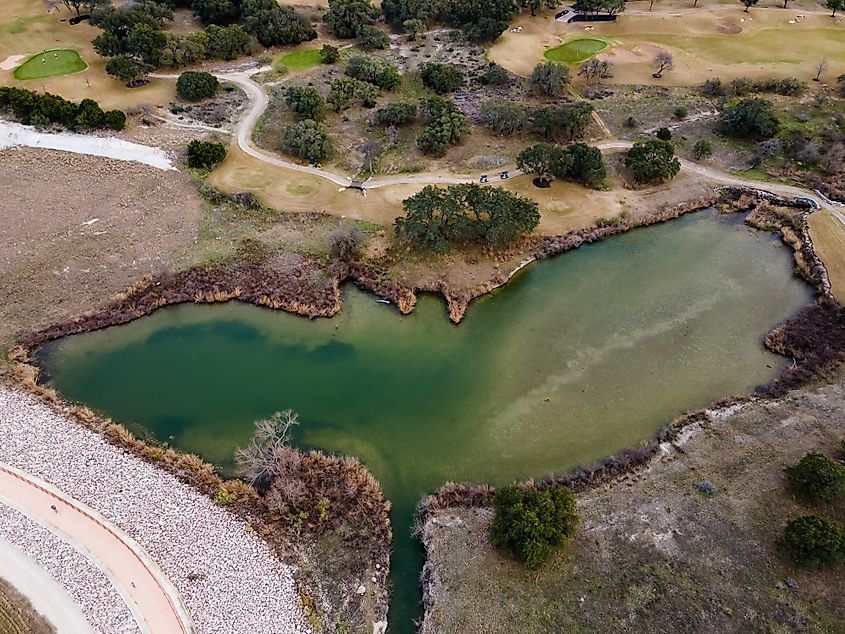 Scenic bike and running trail in Leander, Texas, with a calm body of water and natural landscape in the background