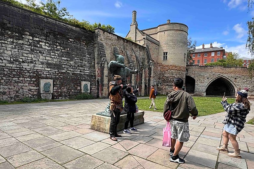 Ade Andrews in character as Robin Hood beside the Nottingham statue