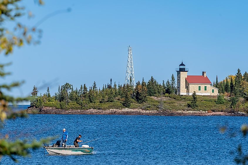 Copper Harbor Lighthouse on Lake Superior, with fishermen in a boat