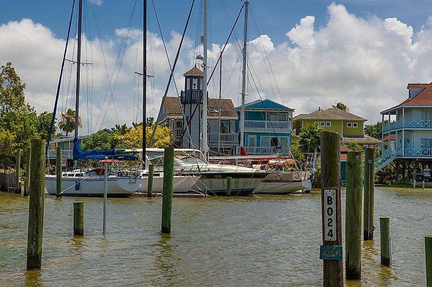 Kemah harbor in Kemah with houses lining the shoreline and boats moored along the water