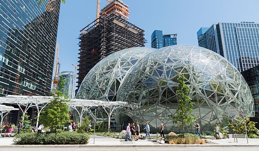 Seattle, Washington circa May 2018 Amazon company world headquarters campus on a sunny blue sky spring day, many people casually walking sidewalk next to Spheres terrariums.
