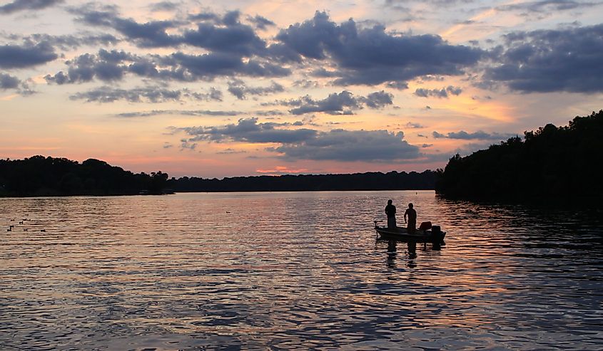 Люди в лодке, закат над озером Олд-Хикори в Нэшвилле, штат Теннесси