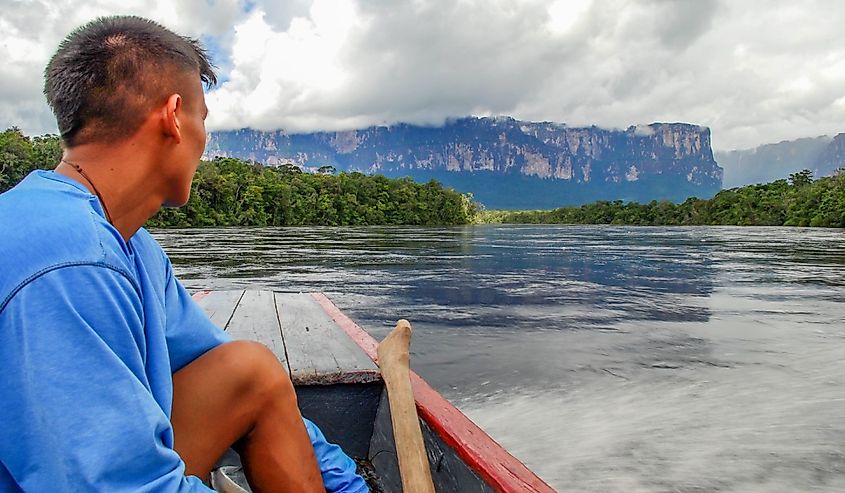 Hombre sentado en una canoa camino a visitar el Salto Ángel