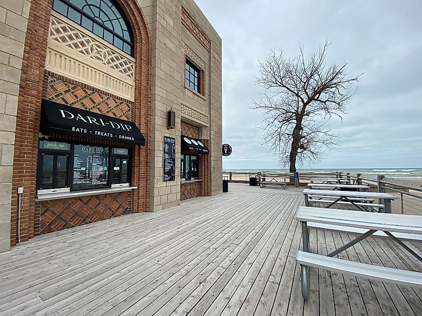A beachside pavilion with take away window and a large wooden patio with picnic tables