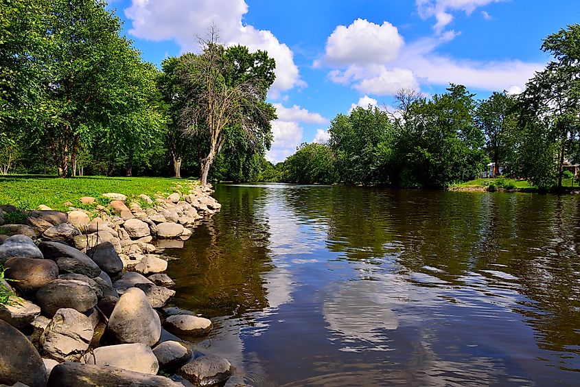 A beautiful view of the Fox River with rock boarder looking east at Wehmhoff Jucker Park in Burlington Wisconsin on a lovely summer afternoon.