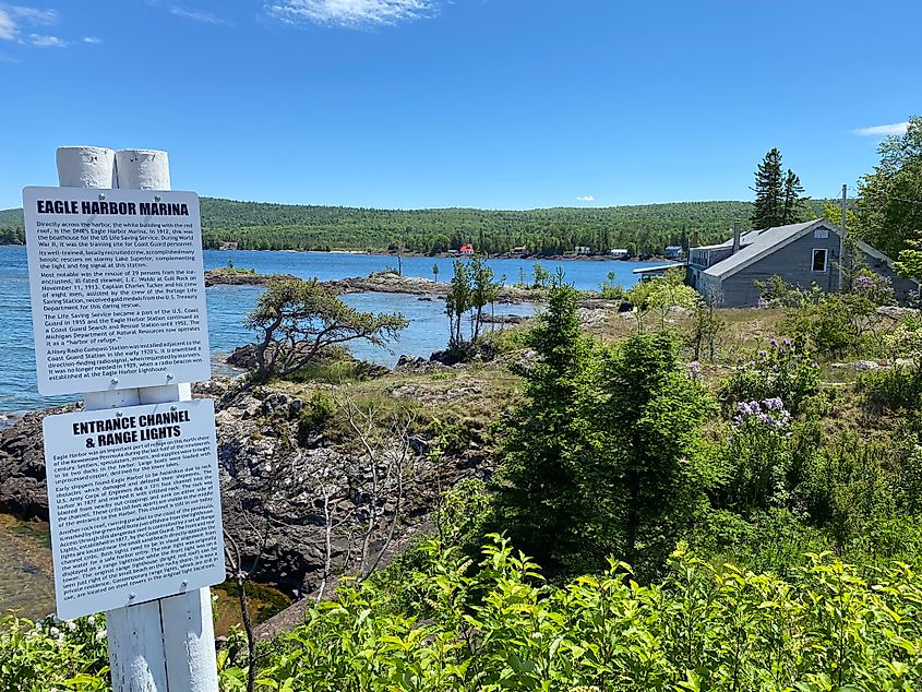 Signs for Eagle Harbor Marina stand before a green and blue naturescape.