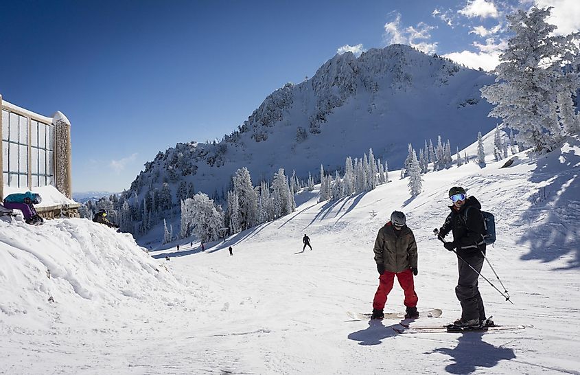 December 23, 2014 - Huntsville, Utah, USA. A skier and a snowboarder enjoy the snow and sun at the top of the lift at Snowbasin in Huntsville Utah.
