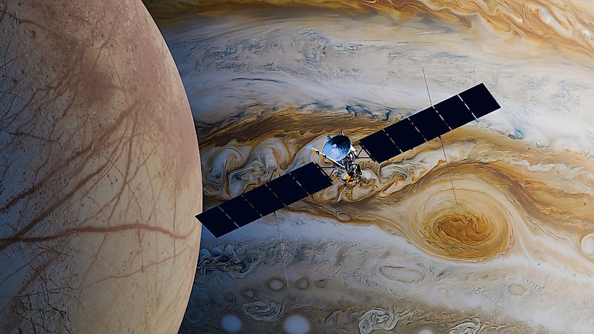 Illustration of the Europa Clipper spacecraft flying past Jupiter's moon Europa