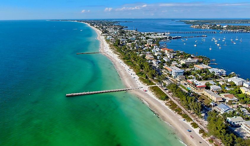 Aerial view of Cortez beach with sand beach and his little wood pier on blue water, Anna Maria Island, Florida