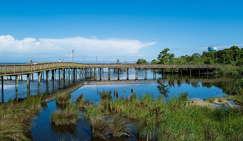 A wide angle photo of the boardwalk that crosses over the water of Currituck Sound in Duck, North Carolina