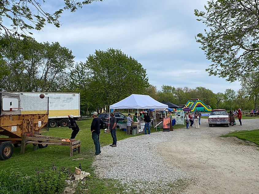 A small community pop up fair, with basket ball, a market, live music, and bouncy houses in the background.