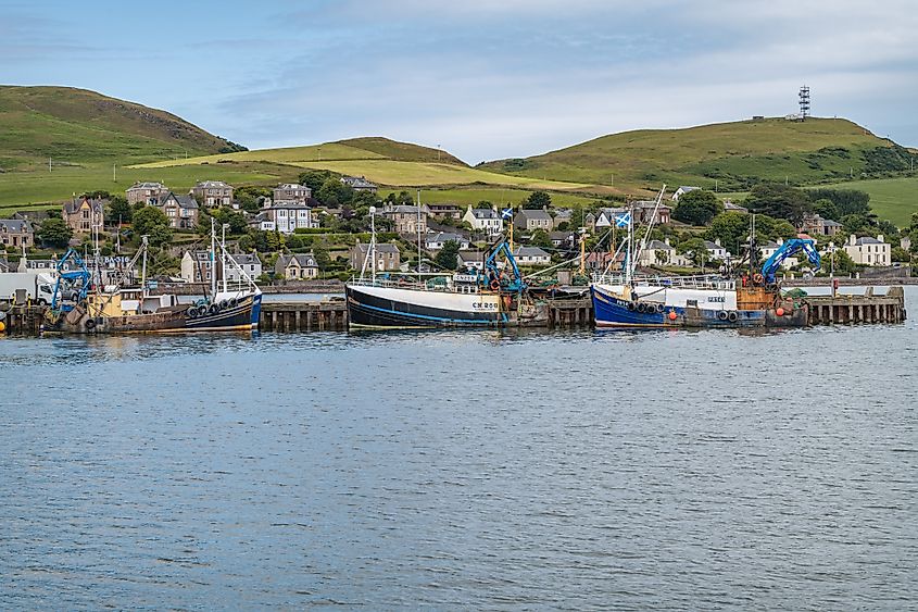 Fishing boats moored in the harbour with Campbeltown in the background (Editorial credit: dvlcom.co.uk / Shutterstock.com)