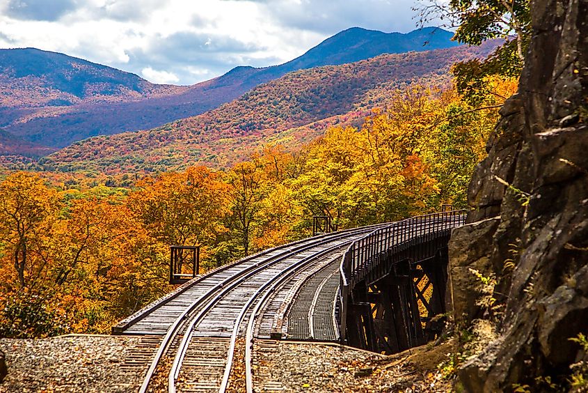 View of Frankenstein Trestle and the White Mountain National Forest from the Conway Scenic Railway on the Crawford Notch route, near Bartlett, New Hampshire. Hardwood trees are showing peak fall color.