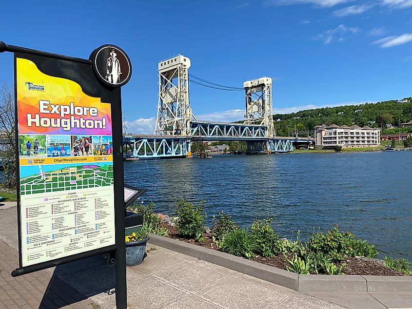 A riverside interpretive sign for the city of Houghton, Michigan, with its massive Portage Canal Lift Bridge in the distance. 