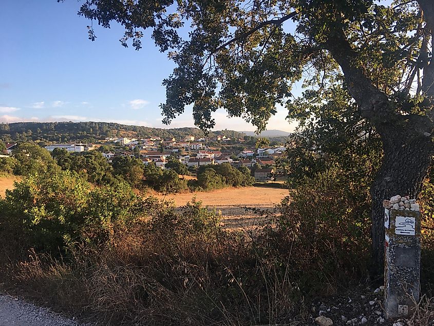 A signpost pointing to Fatima, Portugal, backdropped by a quaint Portuguese town.