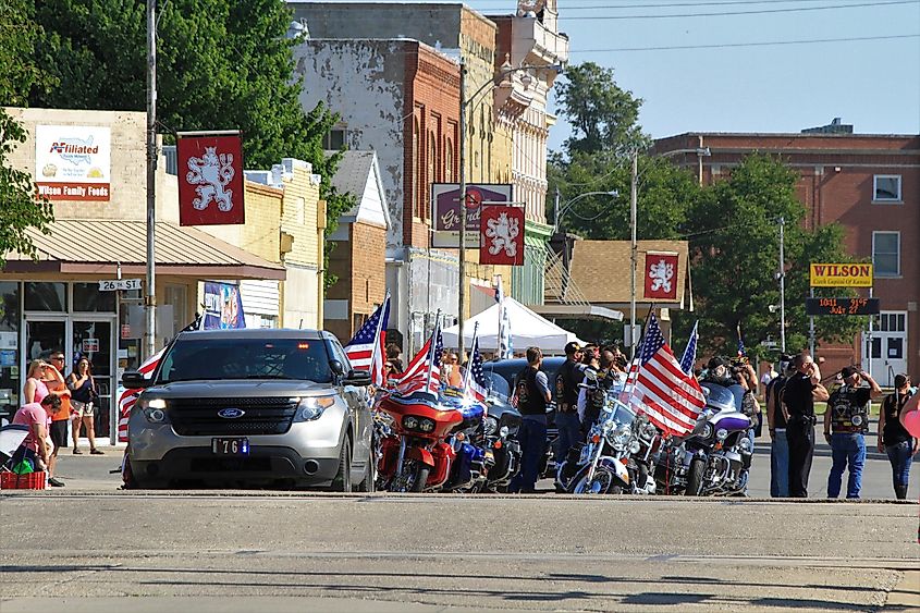 Ellsworth County Sheriff Patrol with veterans saluting the flag on Main Street in Wilson, Kansas, USA, during the Czech Fest Parade.