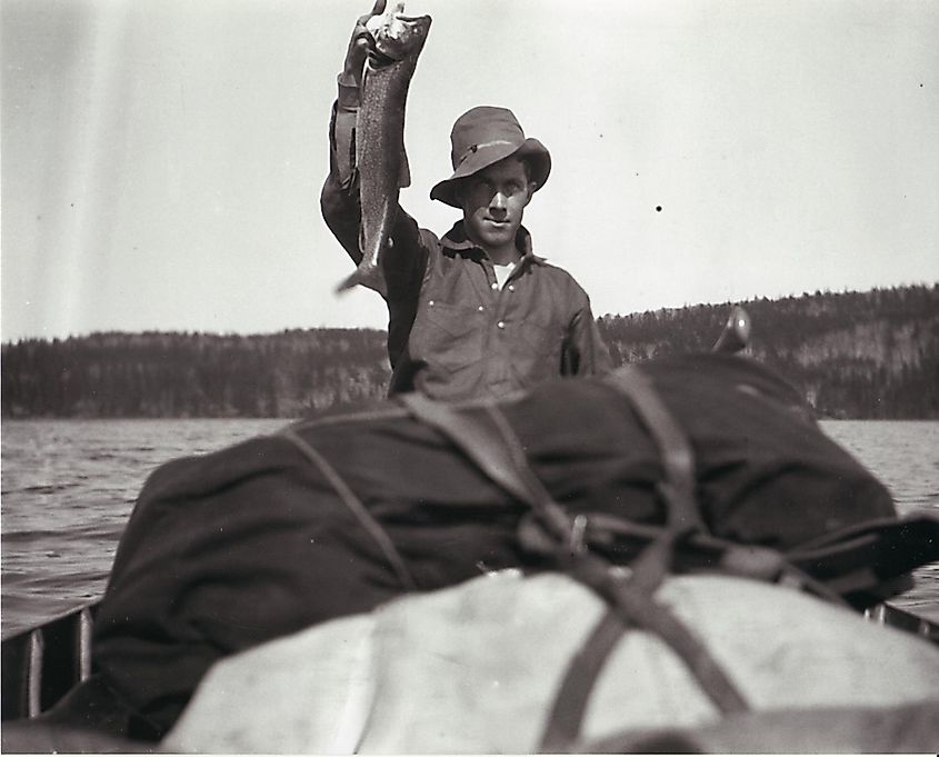 A man in a canoe holding up a fish on Great Bear Lake, Northwest Territories