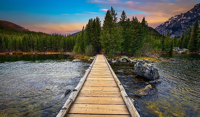 Boardwalk and sunset over Taggart Lake and Grand Teton Mountains in Wyoming