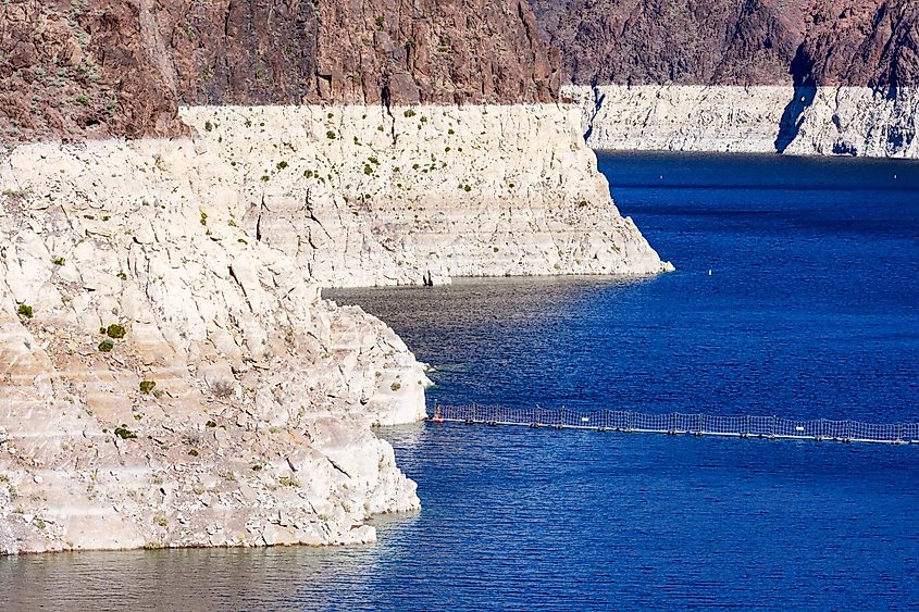 Record low water level of shrinking Lake Mead exposed white surface on rocky banks amid severe drought in American West.