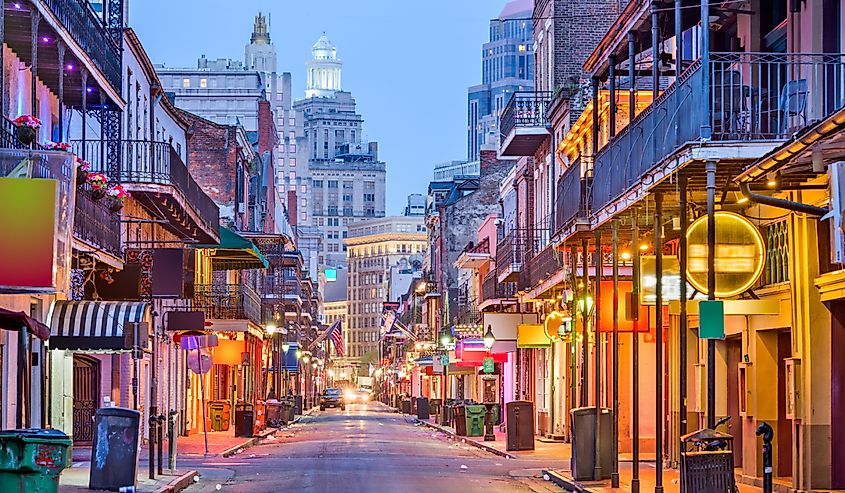 Bourbon St, New Orleans, Louisiana, USA cityscape of bars and restaurants at twilight.